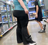 a woman in black pants standing in a store