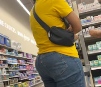 a woman standing in a store with a fanny pack