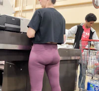 a woman in purple leggings standing in a grocery store