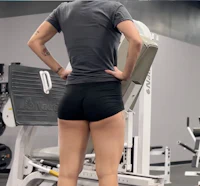 a woman is standing on a machine in a gym