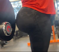 a woman is holding a barbell in a gym