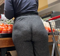 a woman shopping in a grocery store with her back to the camera