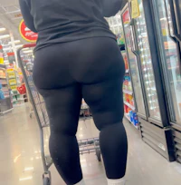 a woman in black leggings standing in a grocery store